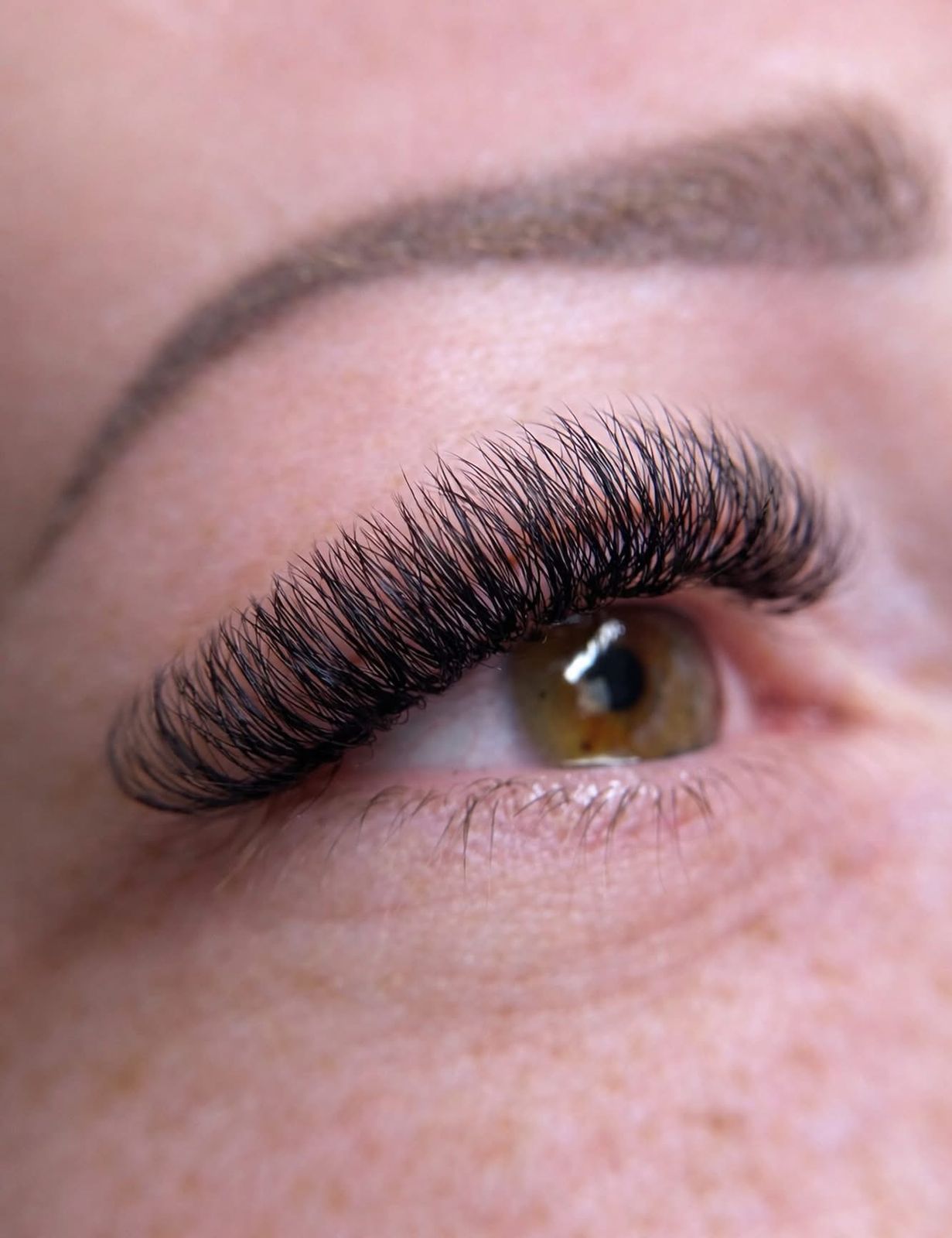 Wimperextensions en een strak gevormde wenkbrauw van dichtbij