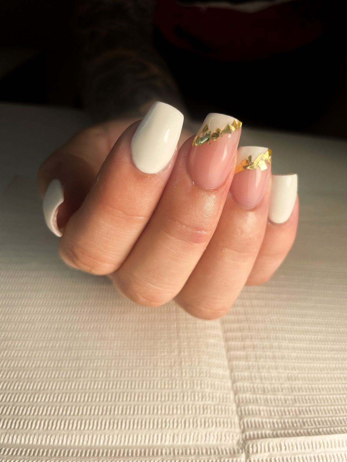 Witte vierkante nagels met goudfolie op twee accentnagels